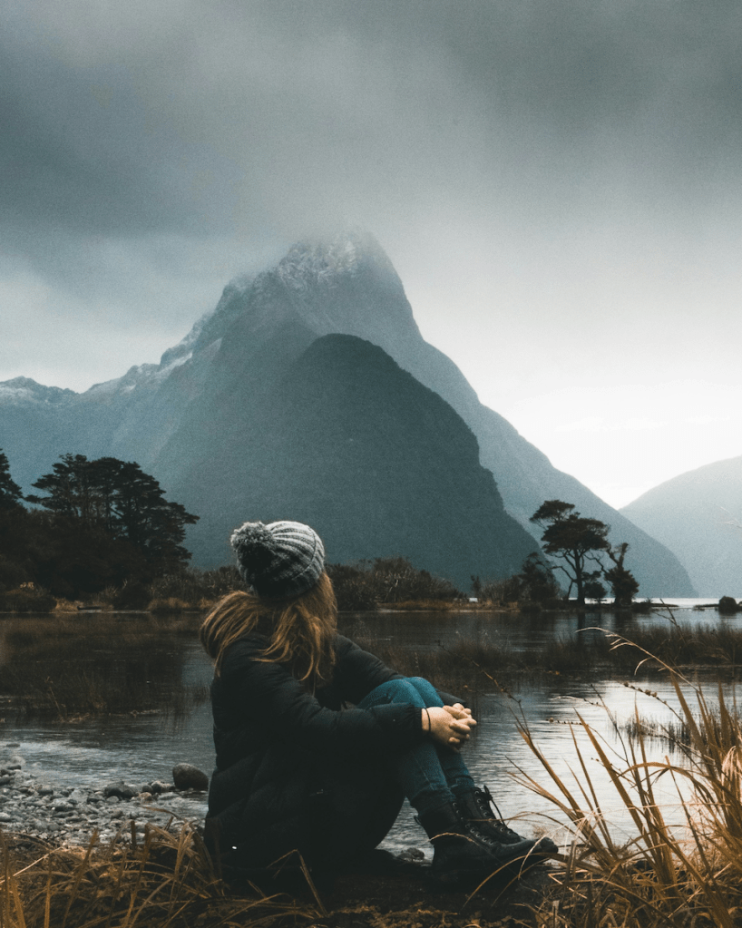 Femail looking at mountain top from Sound, New Zealand